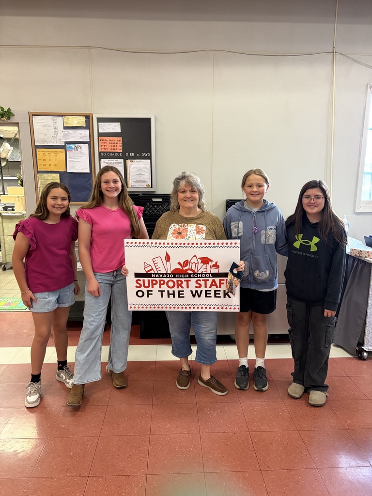 Mrs. Conner with 4 6th grade girls in the cafeteria holding her support staff of the week sign