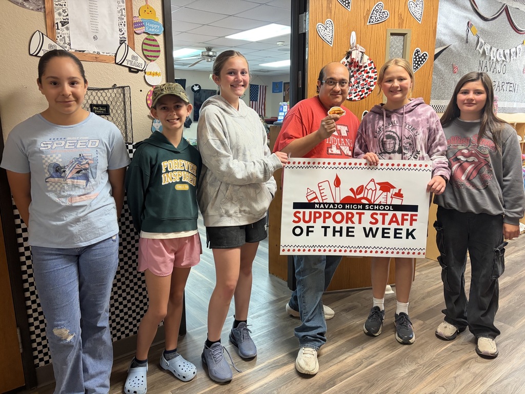 Mr. Andrew with a group of students holding a sign
