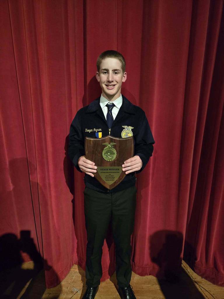 Keegan Ingram Standing with his plaque