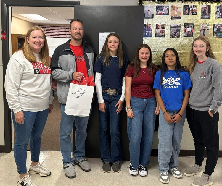 David Doss with students and teachers holding a gift