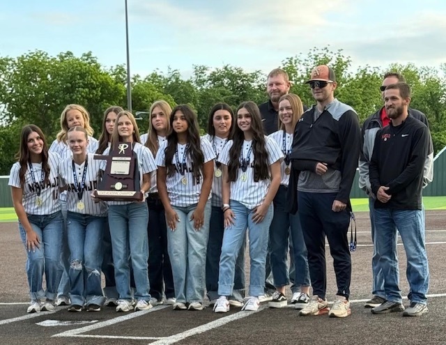 students and staff outside with large plaque