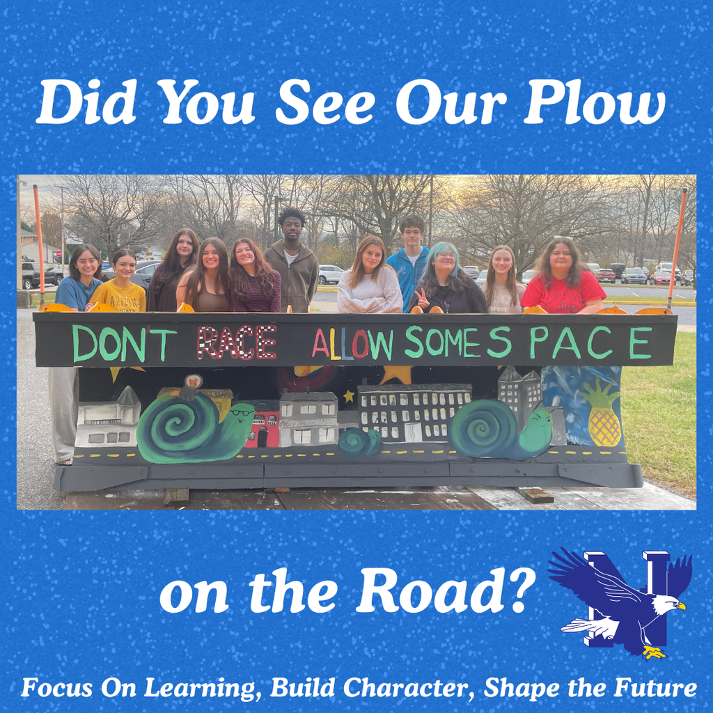 Students standing behind painted plow