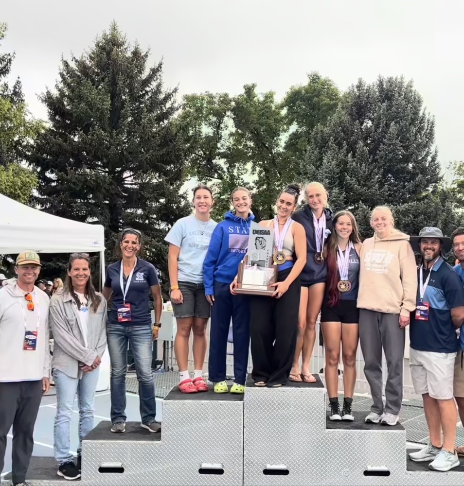State Track 2026- girls team wins 2nd place standing with coaches and girl's team on podium with trophy