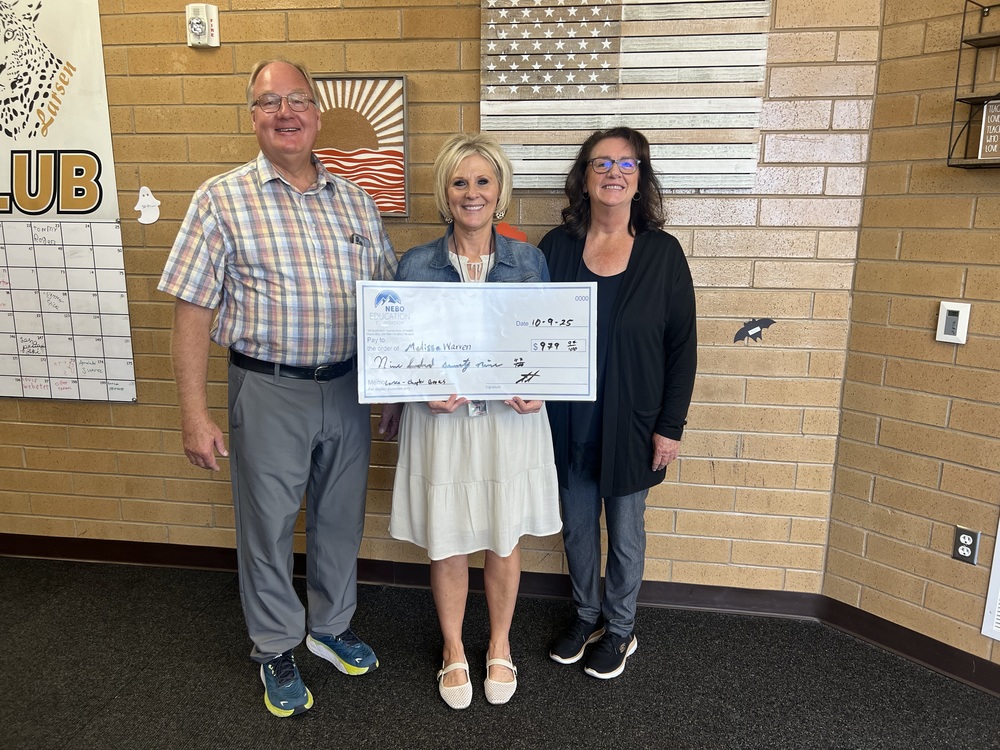 3 adults standing holding a donation