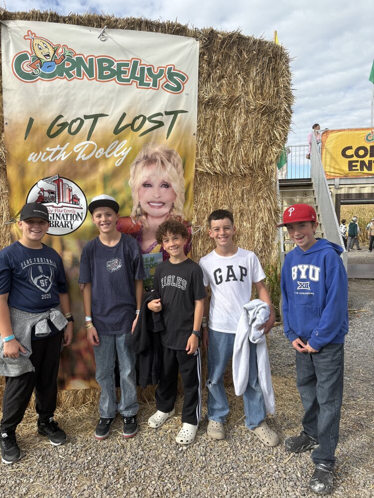 Students next to dolly picture at cornbellys
