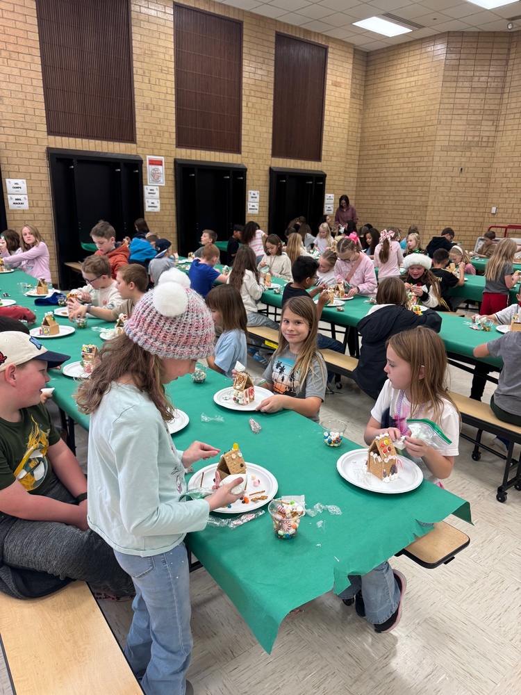 school kids making gingerbread houses