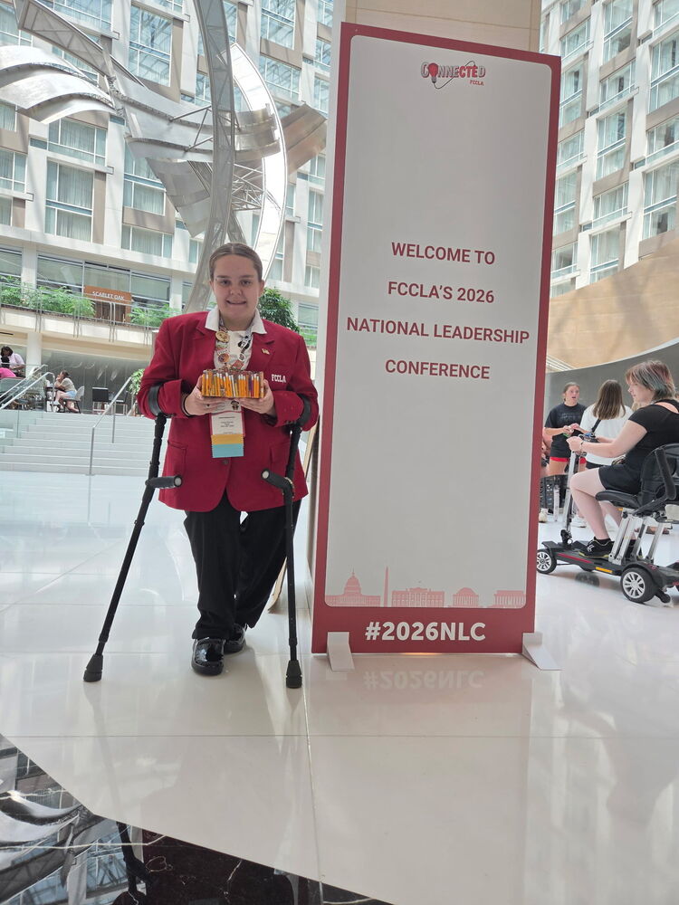 Cadence standing next to a sign welcoming her to the FCCLA National Leadership Conference.
