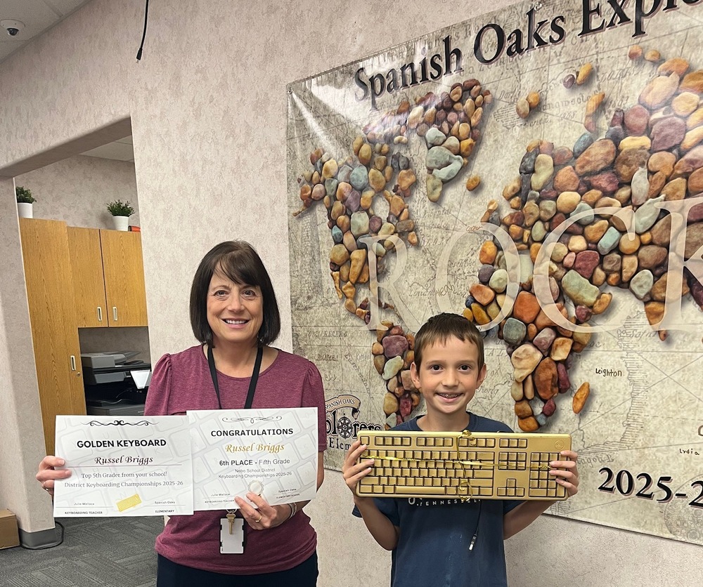 keyboarding winner holding his certificates and golden keyboard!