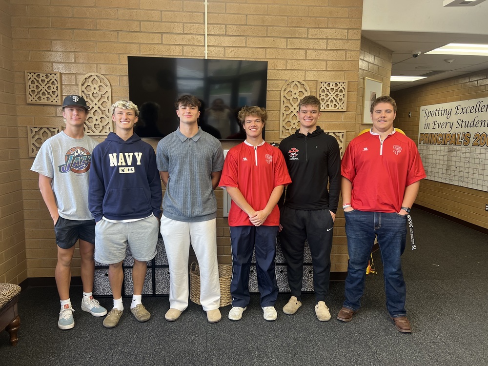 high school boys standing in front of TV