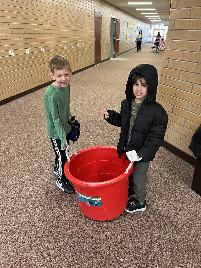students helping each other hold a bucket