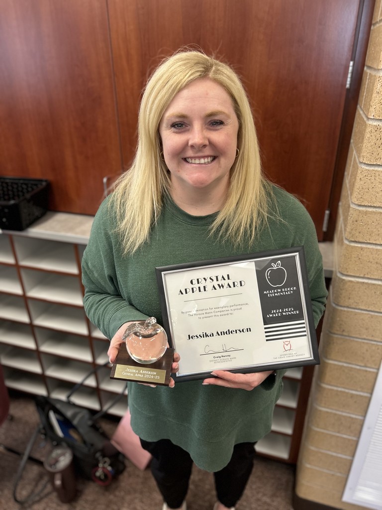 Teacher holding the Crystal Apple award