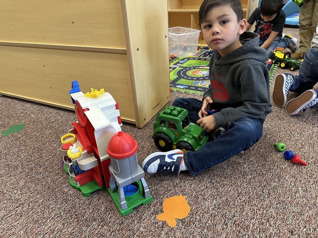 student playing with farms toys