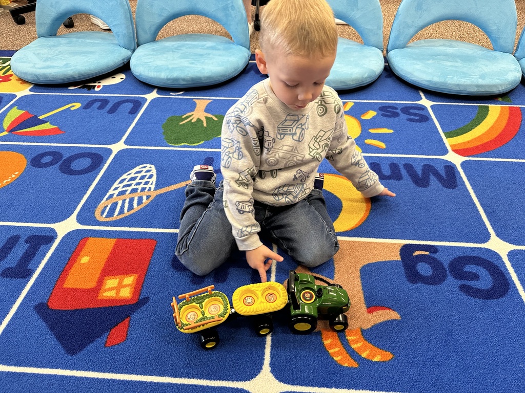 student playing with a farm truck