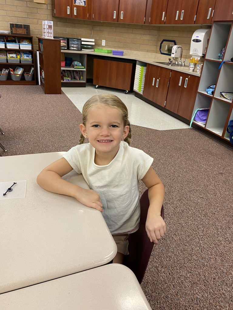 A first grade student at her desk.