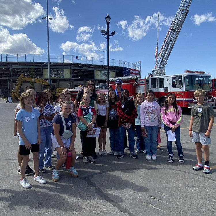 a group of students standing in front of a fire truck