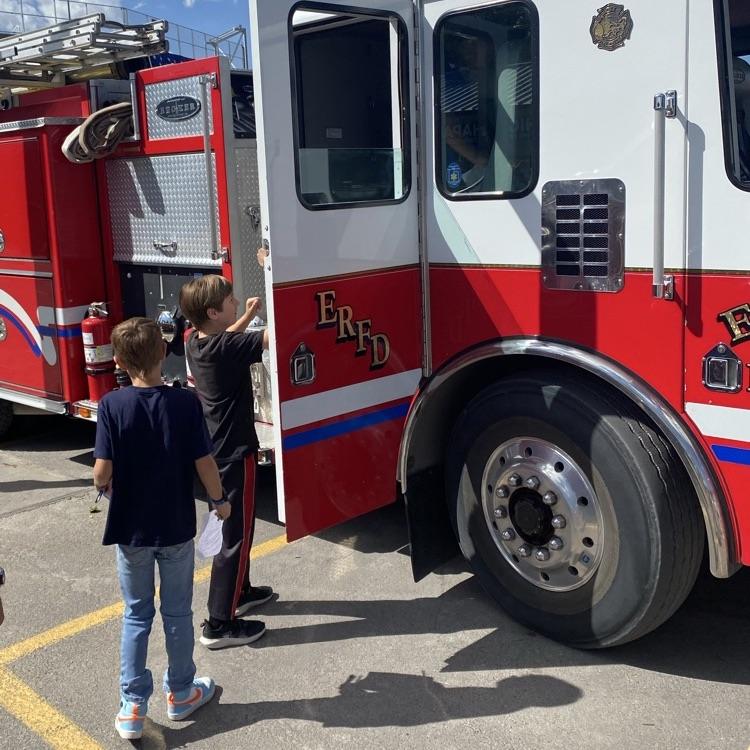 Two kids looking at a fire truck