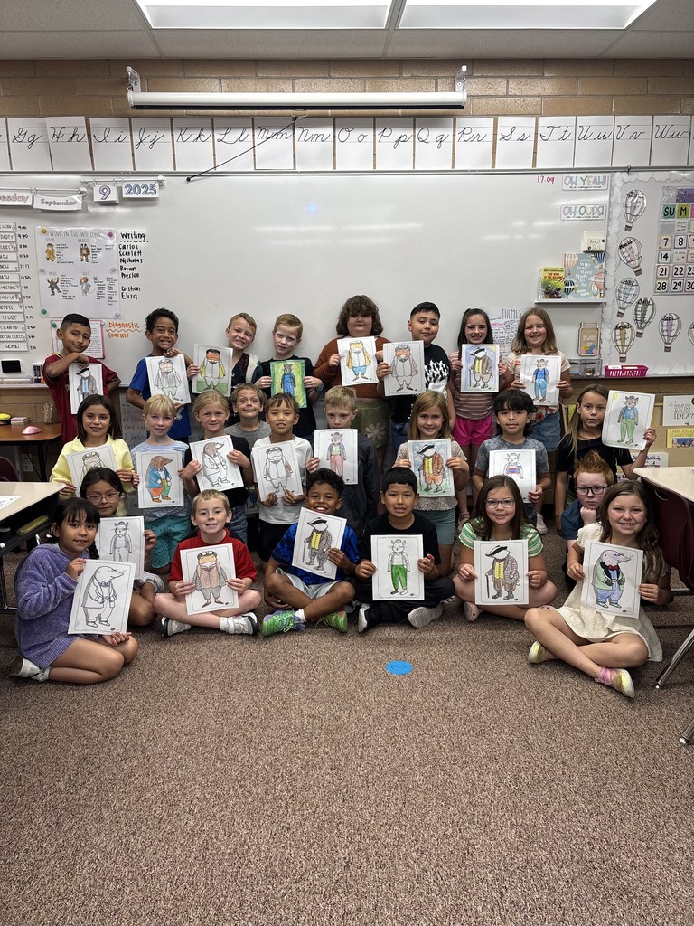 students posing with pictures they drew