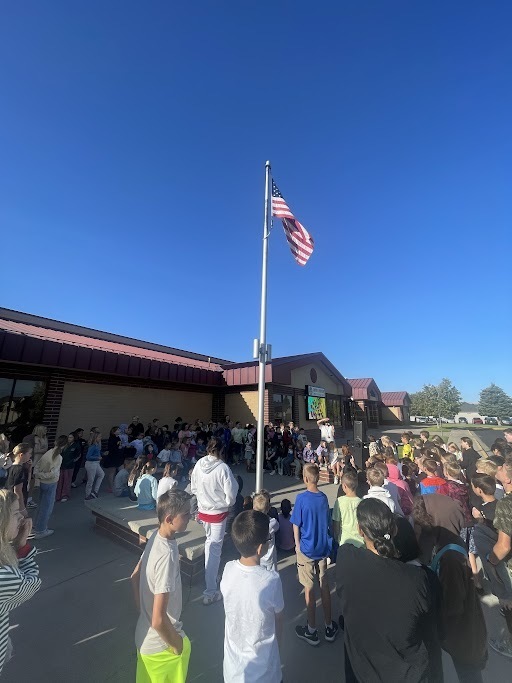 Students sitting around the flag pole learning about the Constitution
