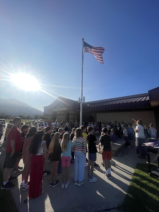 Picture of students singing around the flagpole and learning about constitution day
