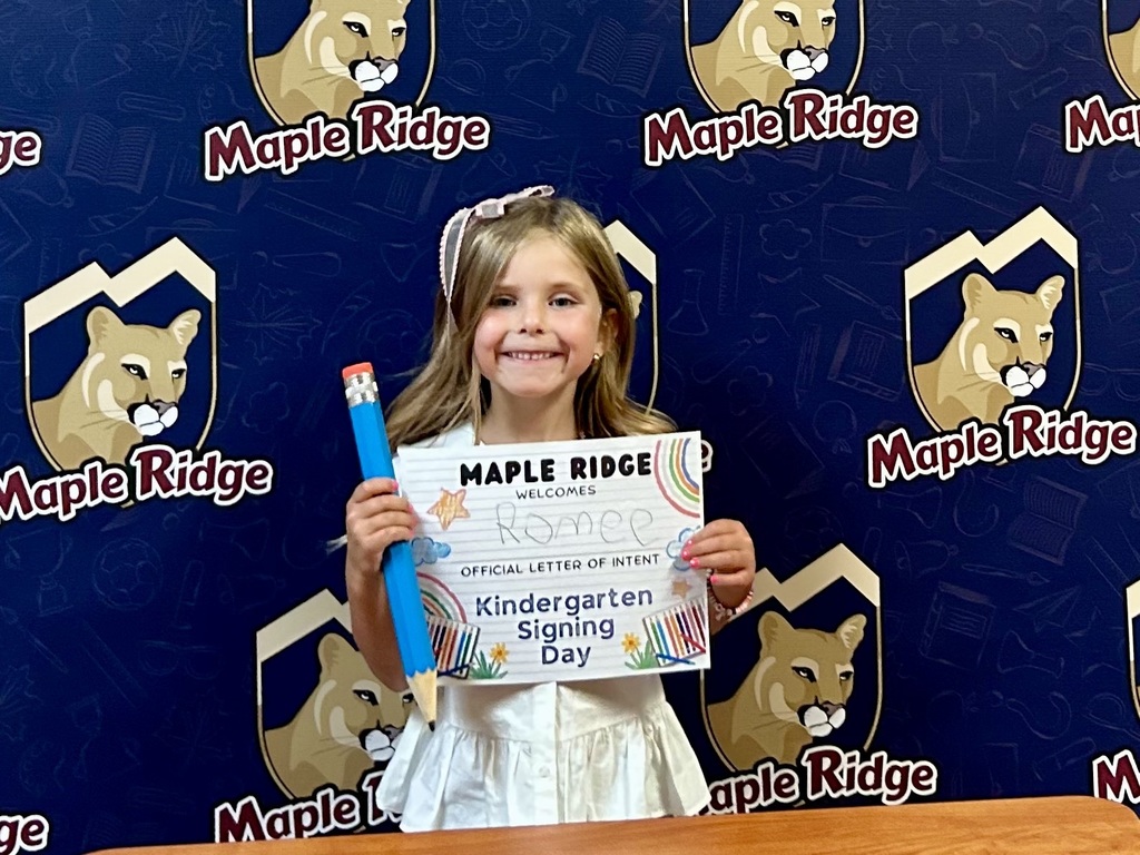 Students in front of a Maple Ridge backdrop holding their "Letter of Intent."