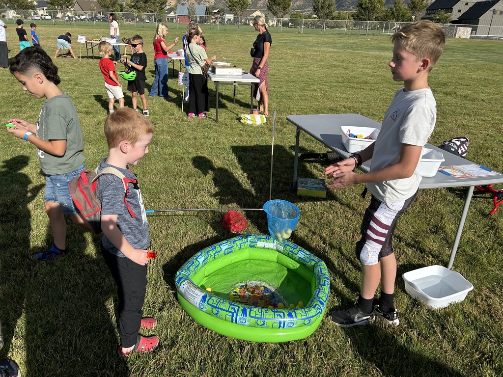Student playing a fishing game with a net.