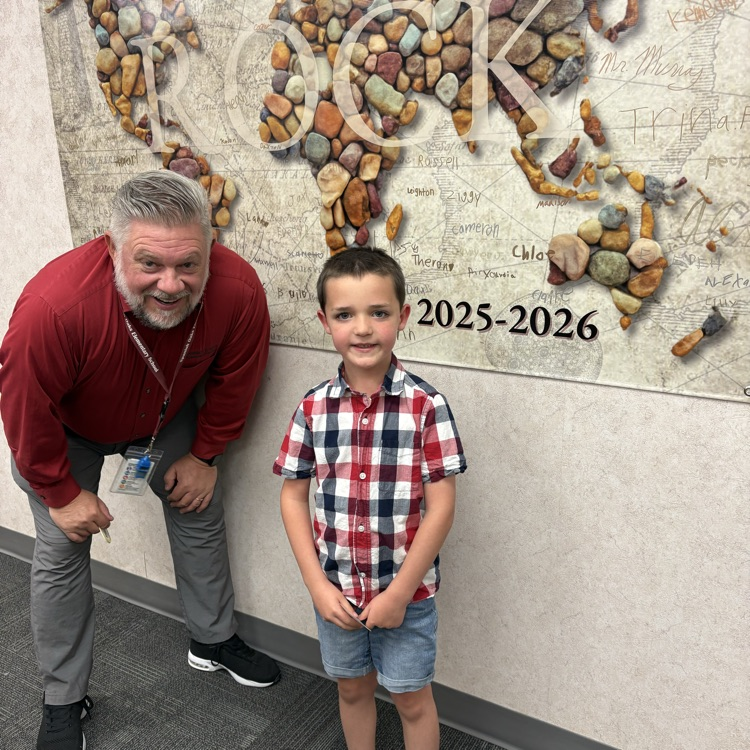 single rock student standing next to poster