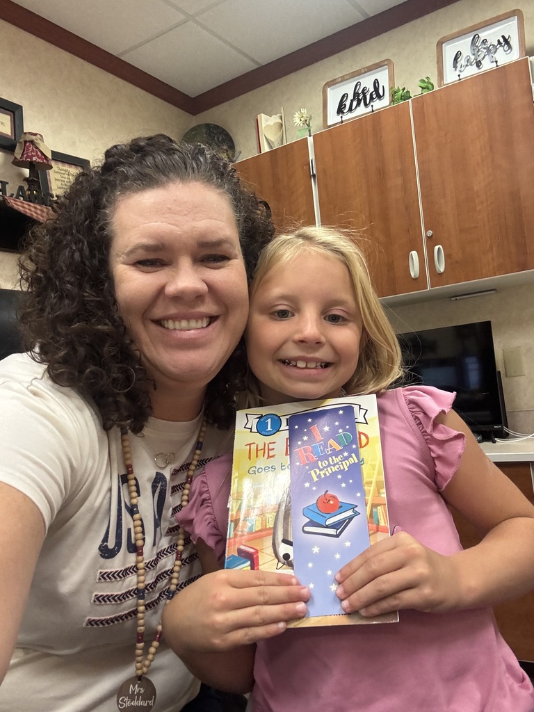 Student reading with the principal