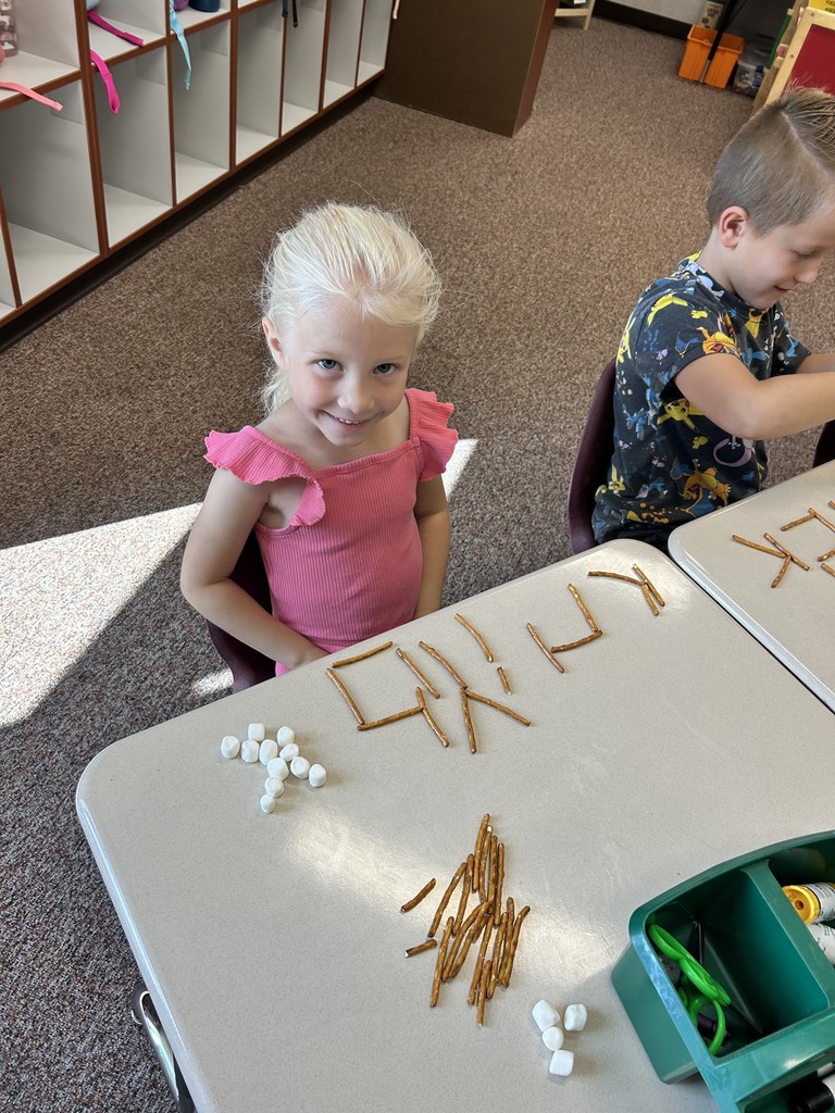 kindergartener spelling name with pretzels