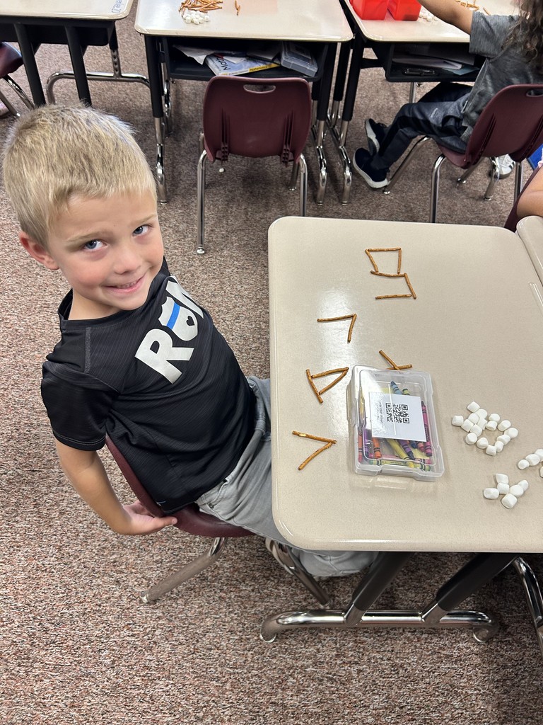kindergartener spelling name with pretzels