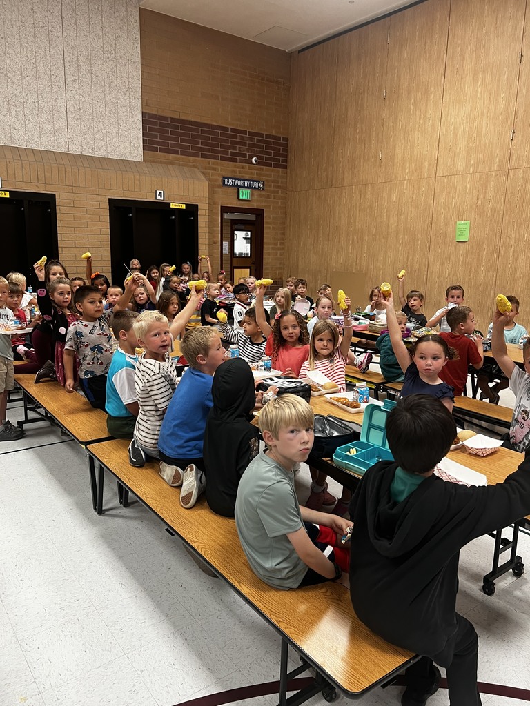 Picture of first grade student holding up corn on the cobb