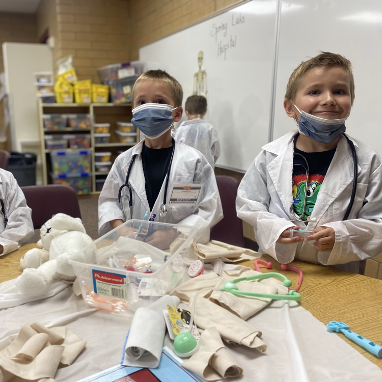 two kids wearing coats and medical masks