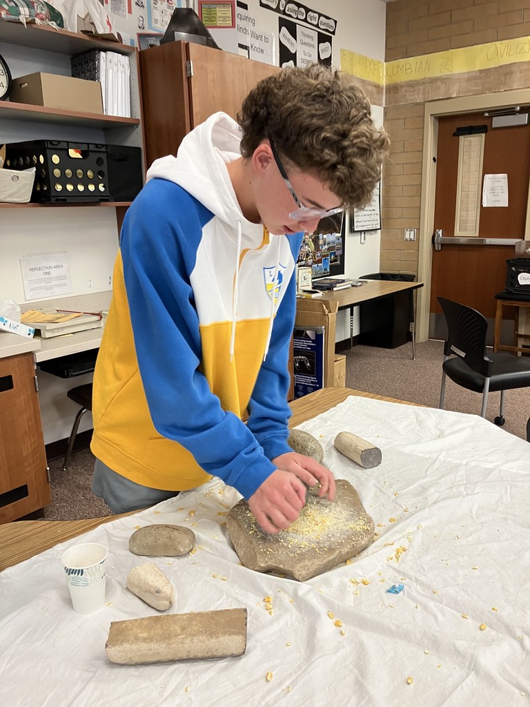 Grinding corn to better understand the culture of ancient tribal groups while in US History.