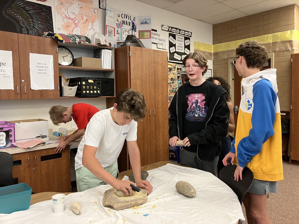 Grinding corn to better understand the culture of ancient tribal groups while in US History.