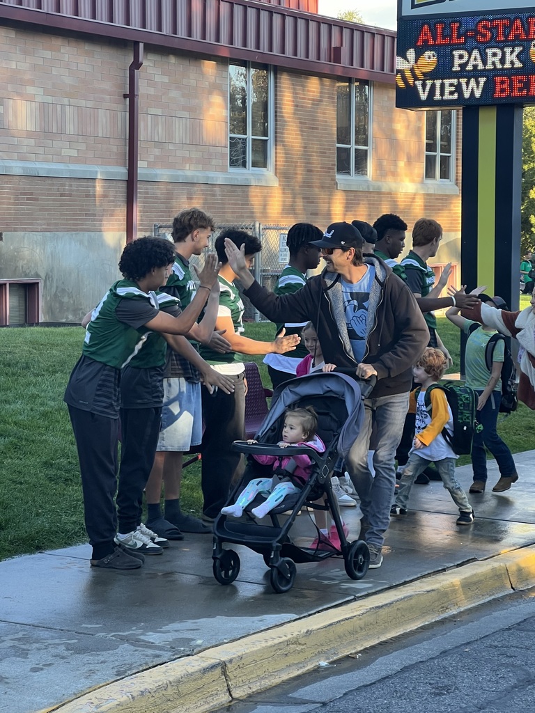 Football players high fiving students and parents