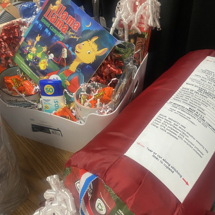 a basket with camping supplies and a sleeping bag
