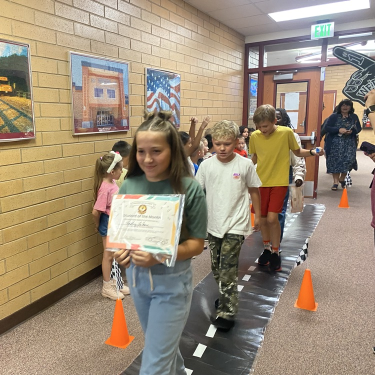 kids walking down the hall while being cheered on by other students