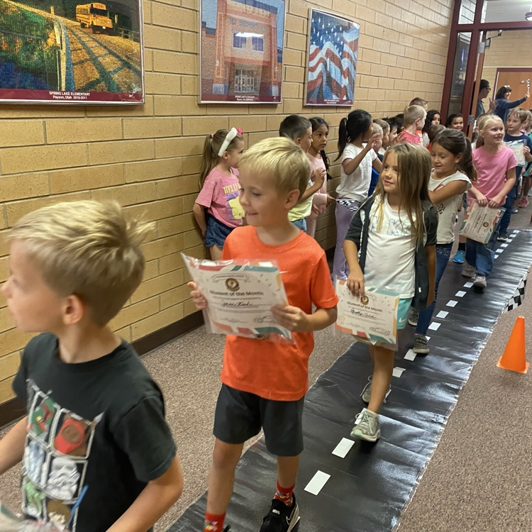 students of the month marching through the hallway