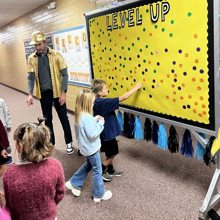 Students placing their Level-up stickers on the Level Up board