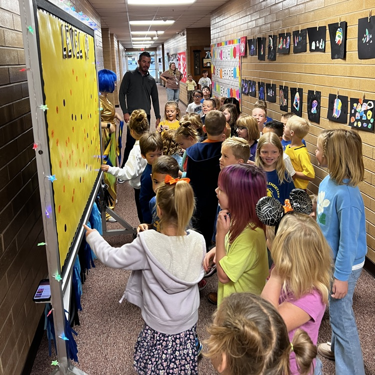 Students placing their Level-up stickers on the Level up board
