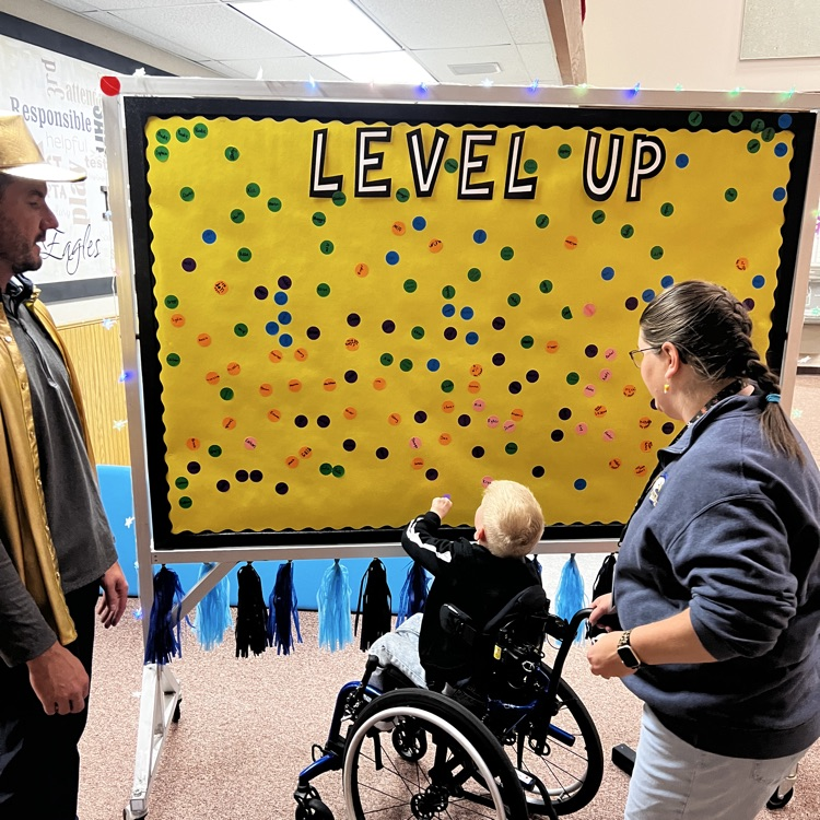 Students placing their Level-up stickers on the Level up board