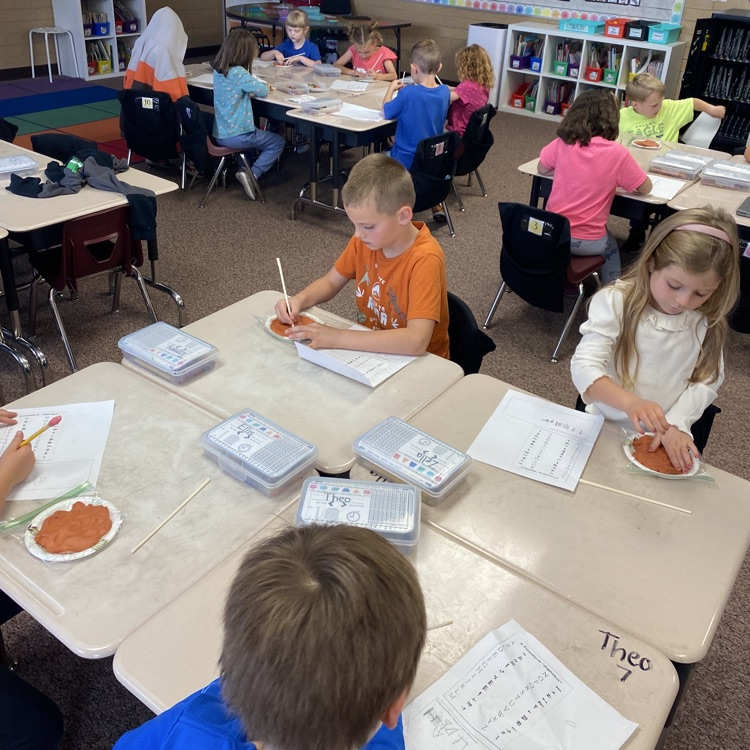 First grade students creating clay tablets 
