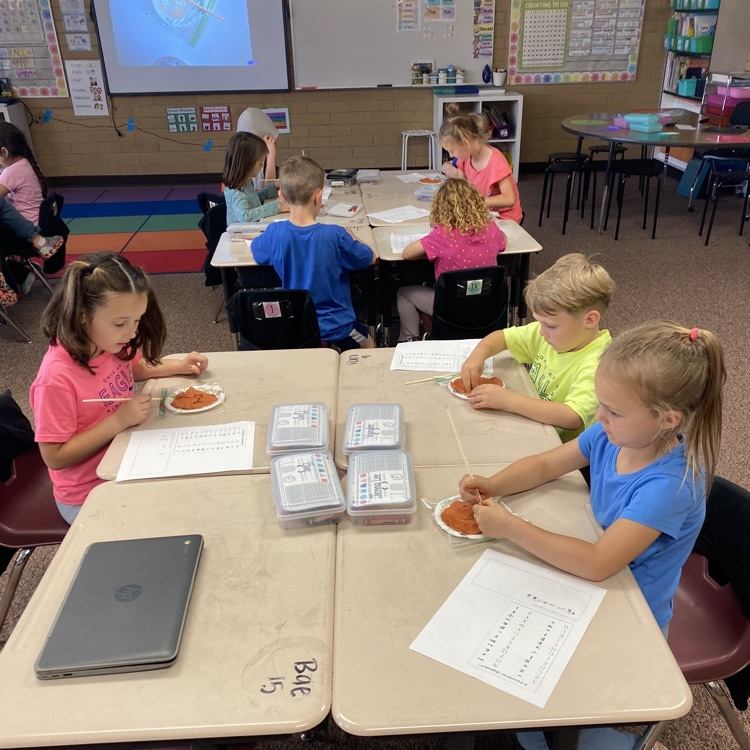 First grade students creating clay tablets 