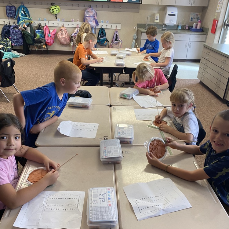 First grade students creating clay tablets 