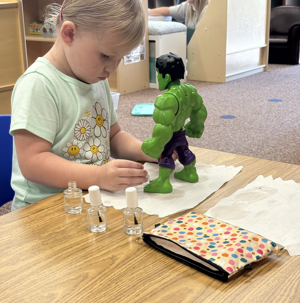 Student painting fingernails of toy
