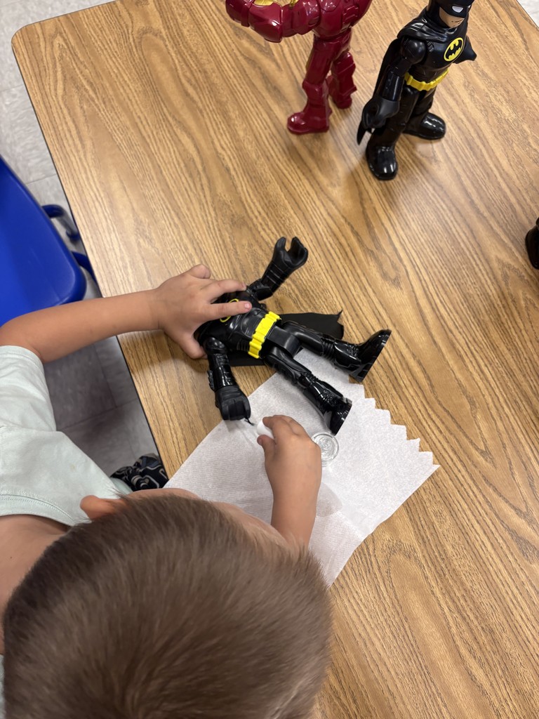 Student painting fingernails of toy