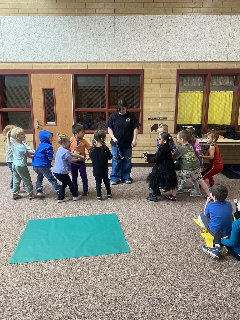 a class of kindergarten students doing a tug of war