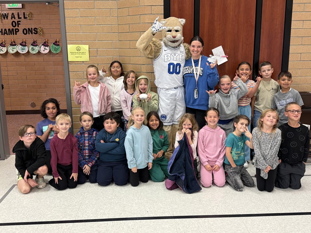 class posing with Cosmo the Cougar for a picture