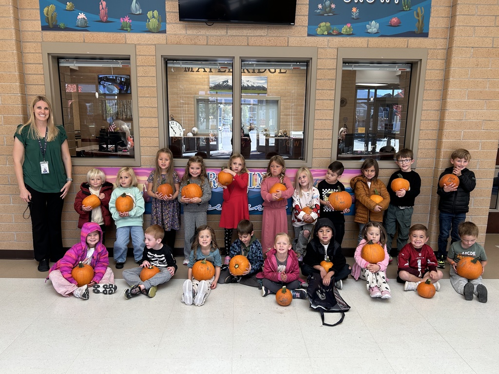 A kindergarten class with their pumpkins. 