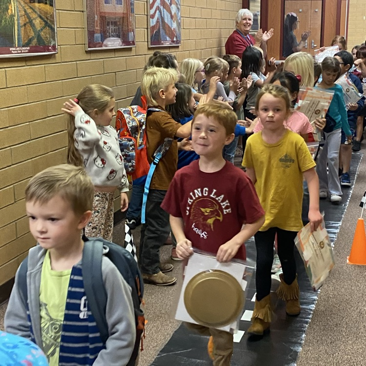 students cheering for the students of the month who are walking down the hall