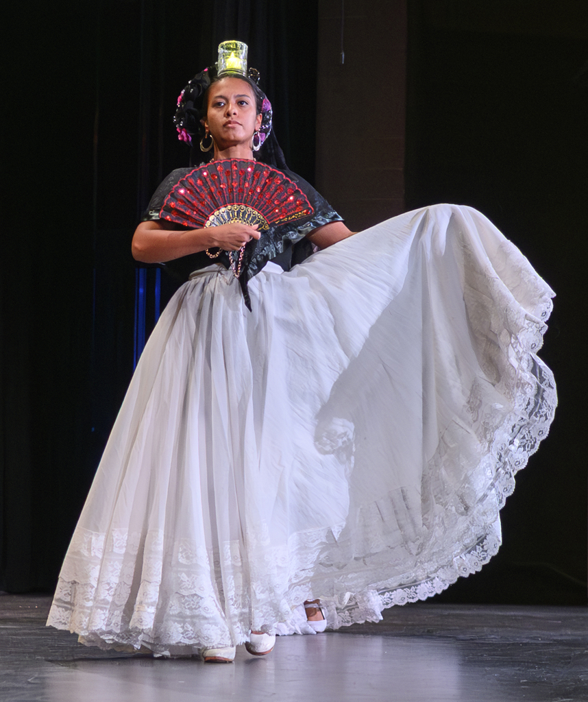 Hispanic Dancer with long white skirt and candle balanced on head for heritage assembly